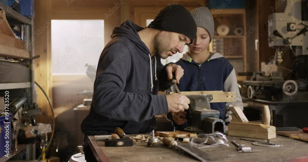 Father and son working together in a workshop Father and son working together in a workshop