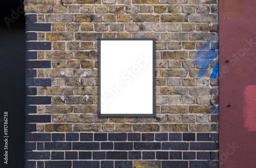 Blank advertising A2 poster billboard on brick wall