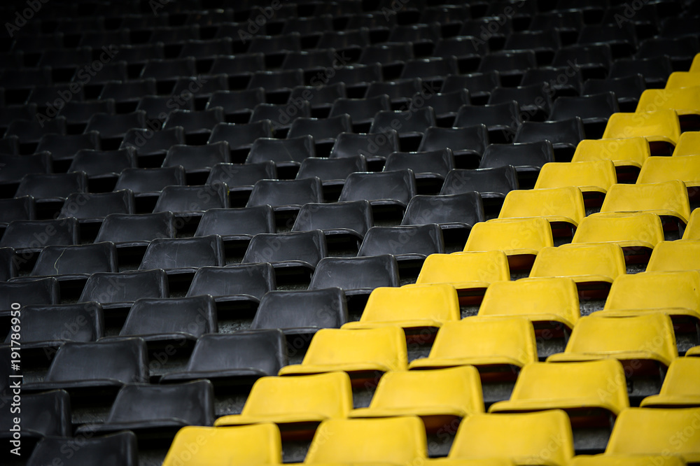 Fototapeta premium gelb schwarz Sitzreihen im Stadion