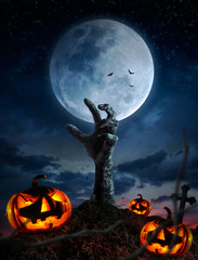 Zombie hands rising in dark Halloween night.
