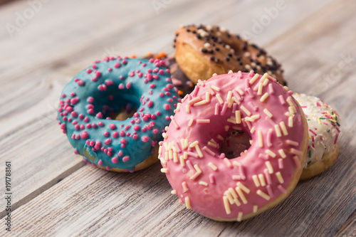 glazed donuts with sprinkles on a white wooden table