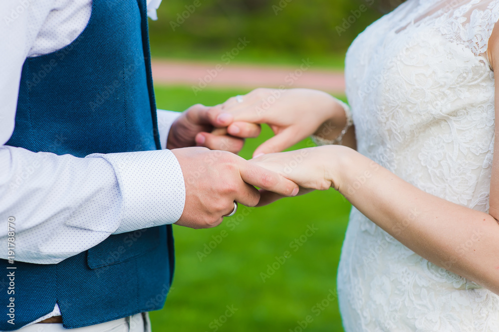 Close-up of groom holding hands of his bride