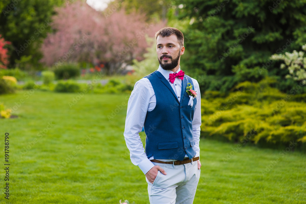Portrait of serious stylish groom outdoors