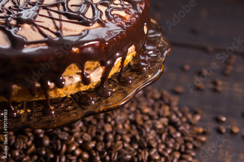 icing biscuit cake soaked in cream on a dark wooden table with coffee beans