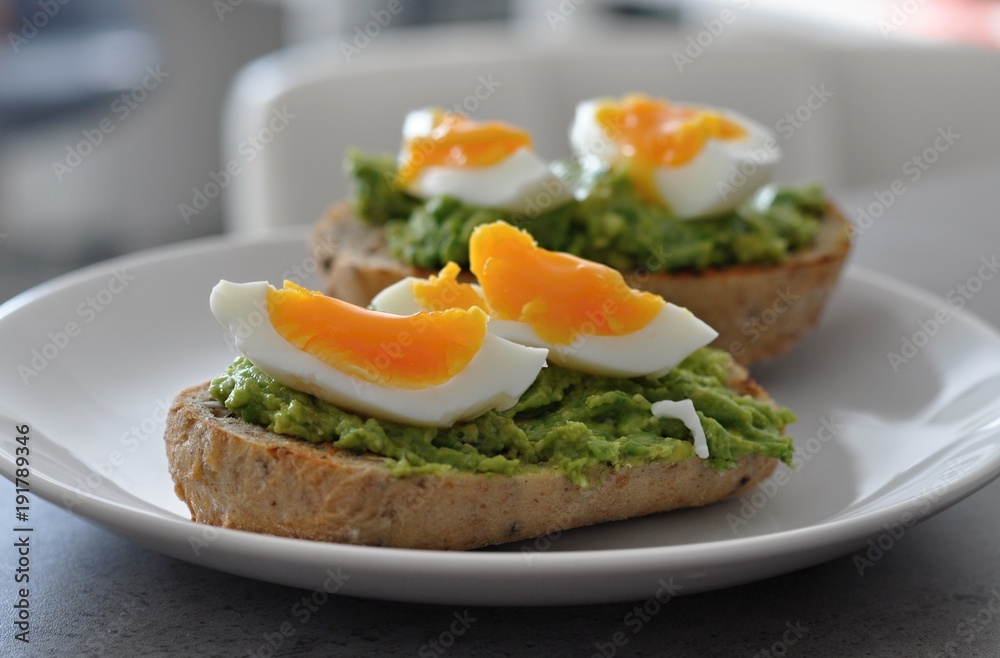 cereal bread with avocado spread and egg on white plate, healthy breakfast, vegetarian food cereal bread with avocado spread and egg on white plate, healthy breakfast, vegetarian food