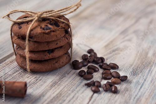 chocolate chip cookies tied with twine with coffee beans and cinnamon stick on white wooden table
