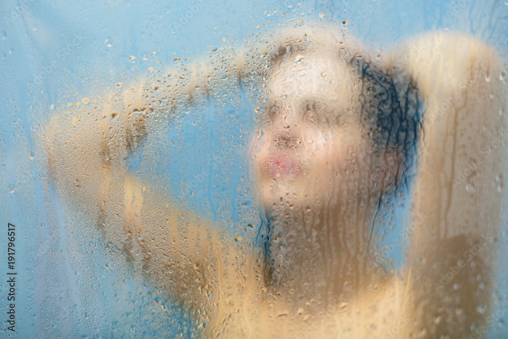 Fototapeta premium Taking moment for yourself. Relaxed unrecognizable woman stands in shower cabin under hot water, feels relief after stressful day, takes care of her body and skin. Relaxation and hygiene concept