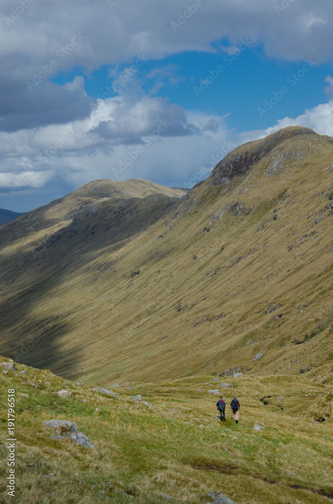 SCOTLAND, UNITED KINGDOM - MAY, 2017 : Trekkers hiking on  the Cape Wrath Trail in Scottish Highlands. Trekkers hiking on  the Cape Wrath Trail in Scottish Highlands.