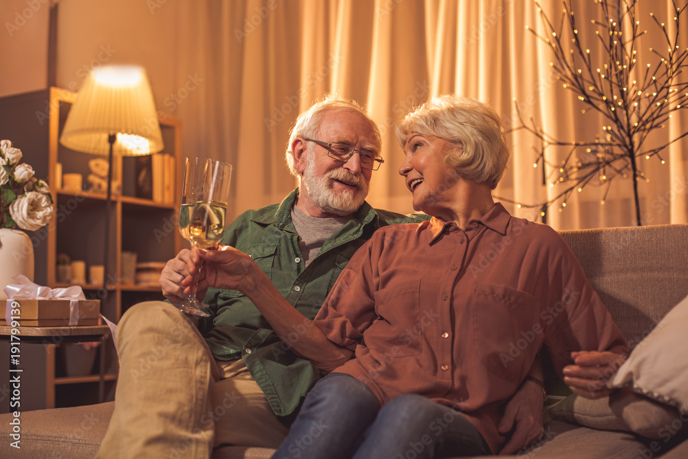 Φωτογραφία Cheerful old man embracing happy woman while tasting glasses of delicious champagne