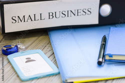 Planning business concept - small business documents  notepad and a pass. Rough bords background. Closeup