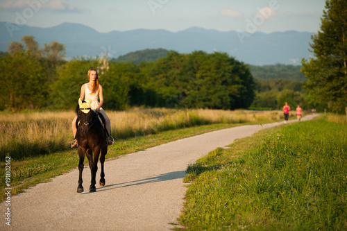 Active young woman ride a horse in nature
