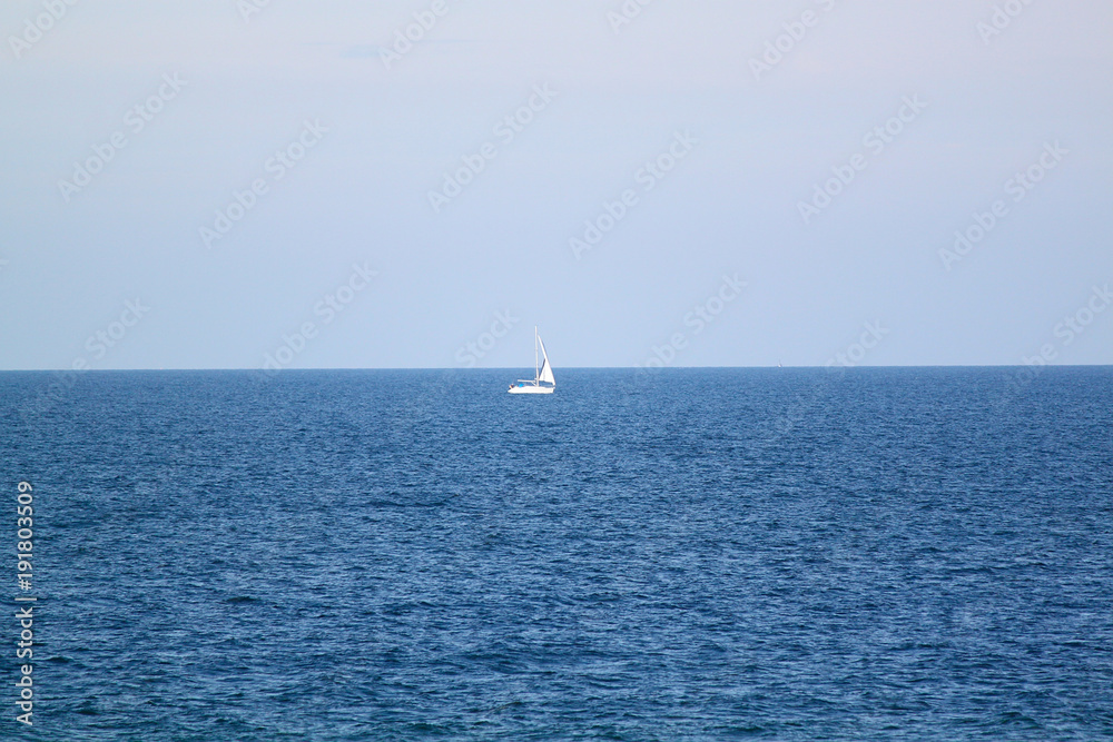 Blaues Meer weißes Segelboot
