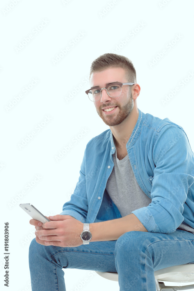 Young man sitting on chair and using mobile phone. Startupper. Young entrepreneur. Young man sitting on chair and using mobile phone. Startupper. Young entrepreneur.