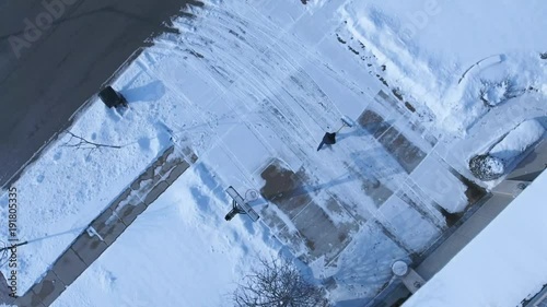 4k Aerial man shoveling snow from his driveway after winter storm