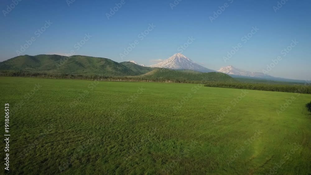 Snow-covered peak, hills, forests and fields Snow-covered peak, hills, forests and fields