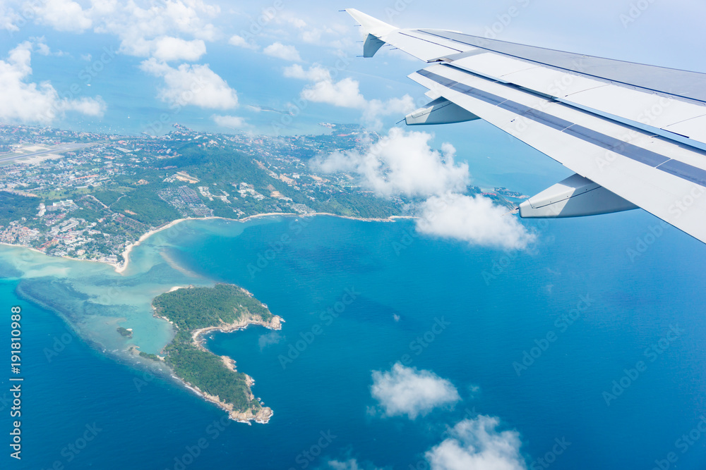 Fototapeta premium Flying away from Ko Samui from plane window island and sea below.