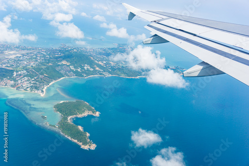 Flying away from Ko Samui from plane window island and sea below.