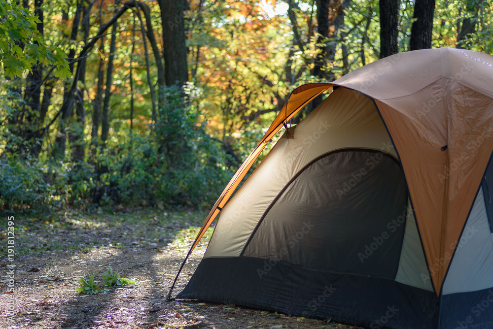 morning light shining on edge of tent in woods on crisp fall morning