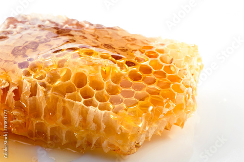 honeycomb piece with honey close-up on white background