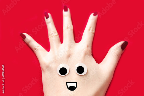 Red Nail Manicure for Valentine. Smile and Funny Face Hand with Red Nails Isolated on the Red Fabric Background Great for Any Use.