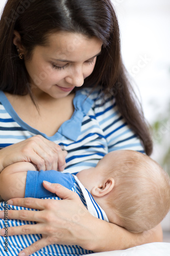Young mother holding baby. ...
