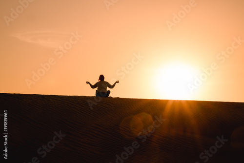 Frau macht Yoga in der Wüste vor Sonnenuntergang