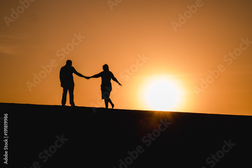 Silhouetten von einem Paar das bei Sonnenuntergang tanzt