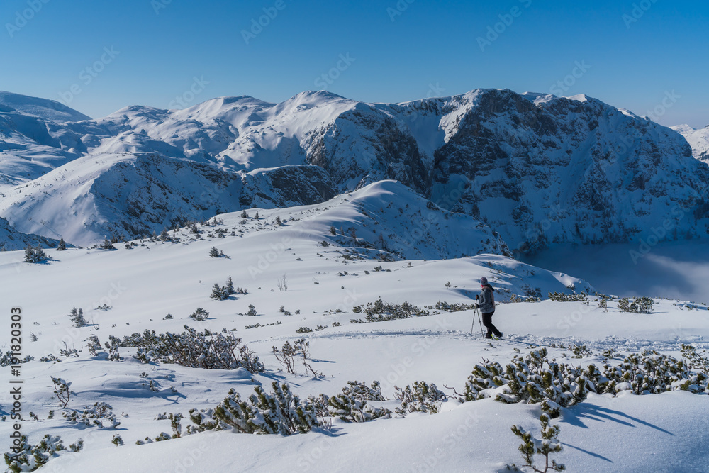 Obraz premium Frau wandert mit Schneeschuhen auf dem Berg