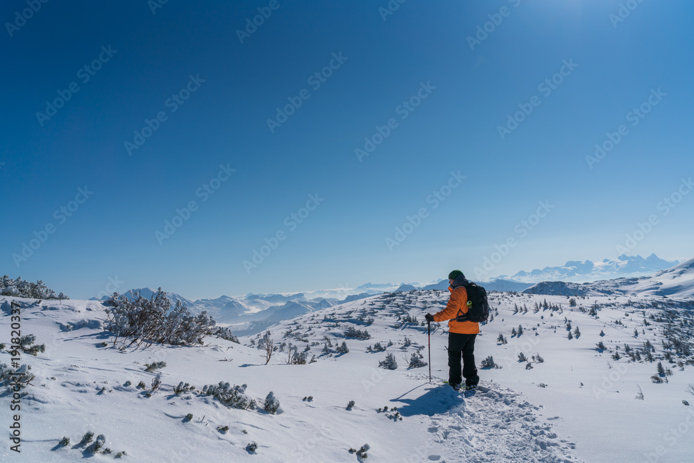 Mann mit Schneeschuhen geht auf den Berg Gipfel