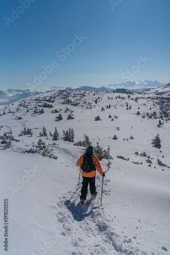 Mann mit Schneeschuhen geht auf den Berg Gipfel