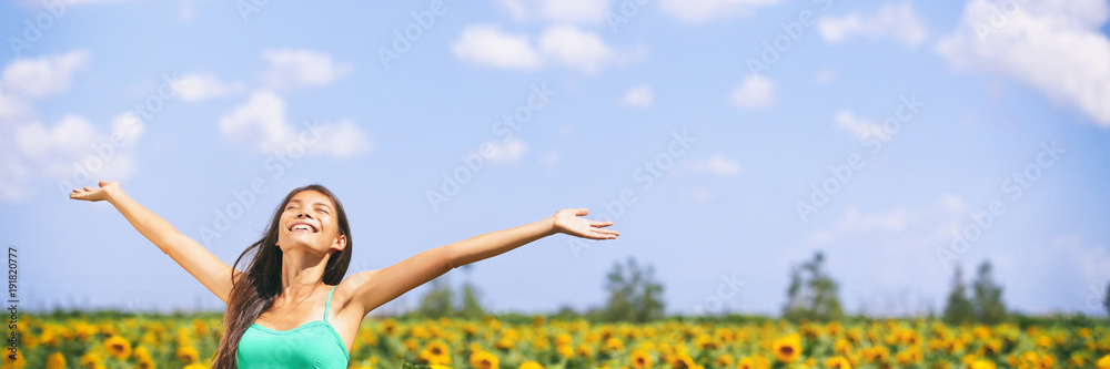 Summer girl happy in sunflower flower field for spring. Cheerful multiracial Asian Caucasian young woman joyful with arms raised up. Panoramic landscape banner. Summer girl happy in sunflower flower field for spring. Cheerful multiracial Asian Caucasian young woman joyful with arms raised up. Panoramic landscape banner.