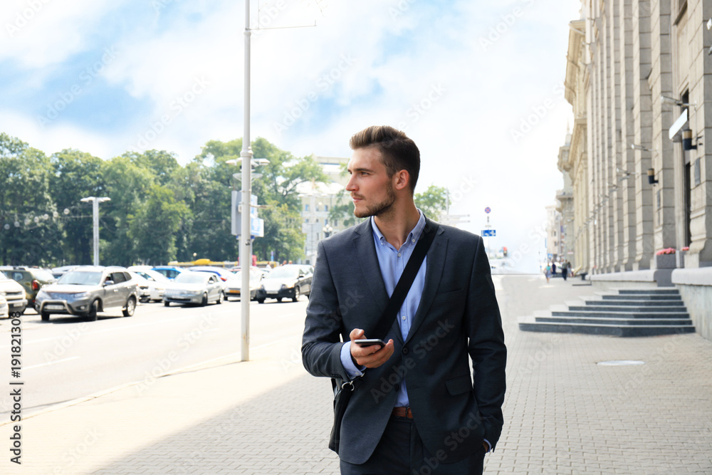 Young urban businessman professional on smartphone walking in street using mobile phone. Young urban businessman professional on smartphone walking in street using mobile phone.