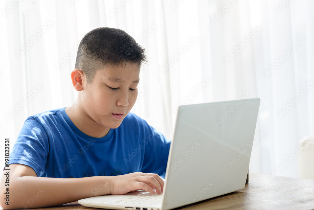 Happy Asian boy using tablet at home. Happy Asian boy using tablet at home.