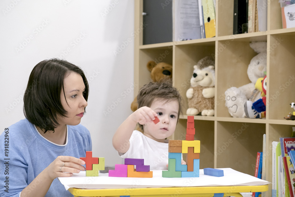 Children playing with blocks on the floor - focus on the boy's face
