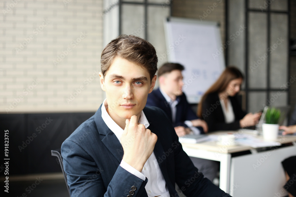 Businessman with colleagues in the background in office. Businessman with colleagues in the background in office.