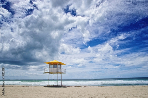 Beautiful view on the beach and lifeguard tower against cloudy blue sky. Beach safety concept.