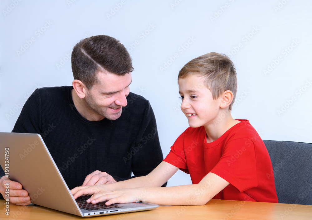 father and son using computer together