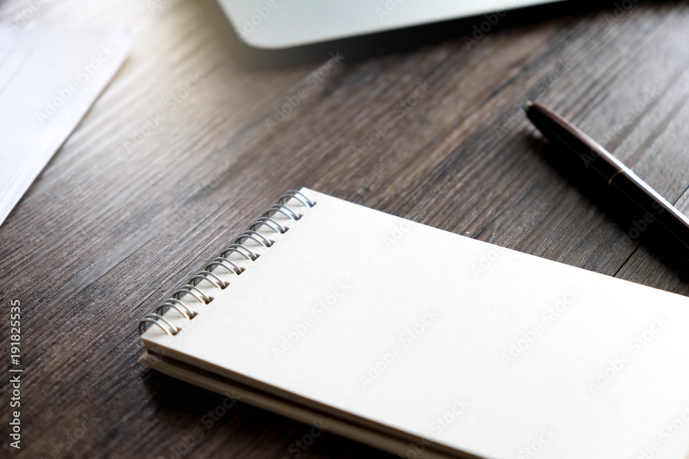 Office workspace with blank notebook , pen , paper sheet and laptop on the wooden table with warm fall colors and soft-focus. Office workspace with blank notebook , pen , paper sheet and laptop on the wooden table with warm fall colors and soft-focus.