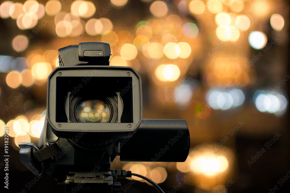 Front view of video camera with light reflection in lens and bokeh light in  background. Selective focus. Stock Photo | Adobe Stock