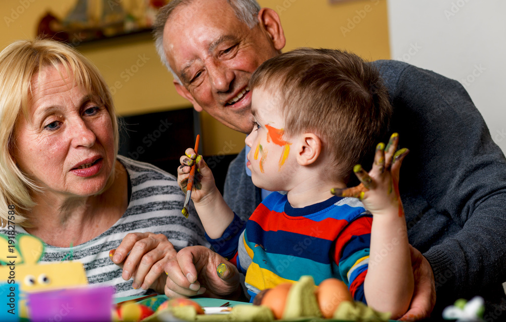 Grandparents with grandson painting eggs for Easter. Grandparents with grandson painting eggs for Easter.