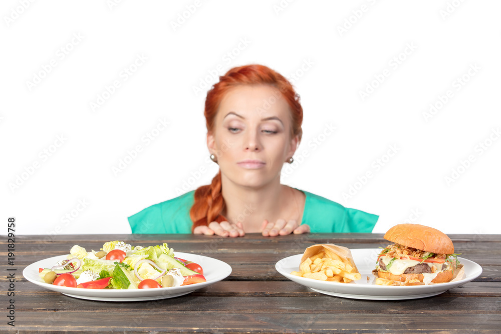 tricky young woman chooses between salad and hamburger tricky young woman chooses between salad and hamburger
