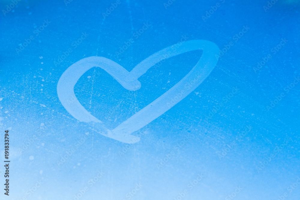The heart is drawn on the window. Heart on blue sky background The heart is drawn on the window. Heart on blue sky background