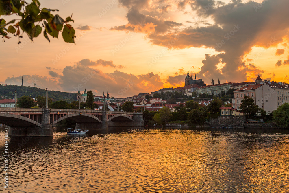 Sunset in Prague with Prague castle, Saint Vitus Cathedral, and the river Vltava.