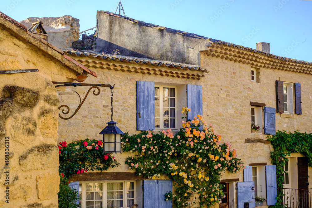 Façade de maison avec une lanterne et des fleurs. Village Ansouis, Provence,  France. Photos | Adobe Stock