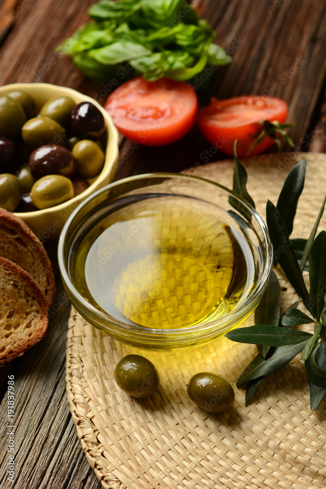 olive oil with twig beside on wooden table olive oil with twig beside on wooden table