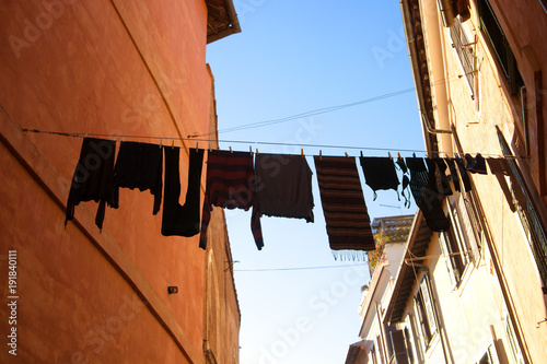Traditional narrow street and old houses with washing hanging on a line in Rome Italy.