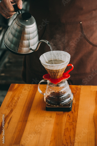 Outdoor summer picnic on the old rustic table. Freshly brewed pour over coffee, dripper photo