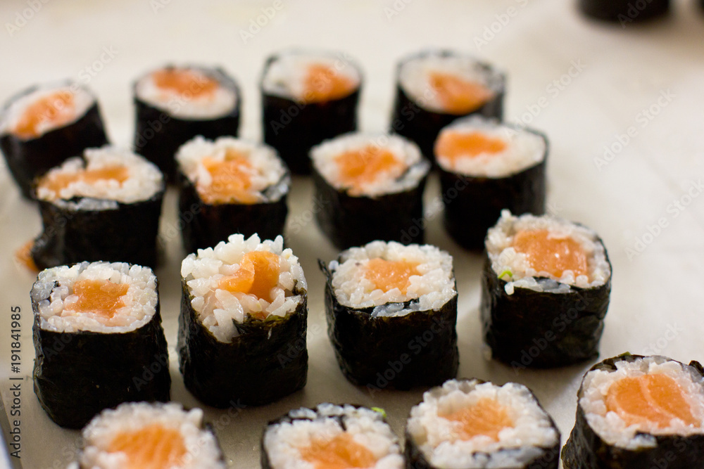 Preparation of Japanese rolls from salmon. Rolls on a metal tray Preparation of Japanese rolls from salmon. Rolls on a metal tray