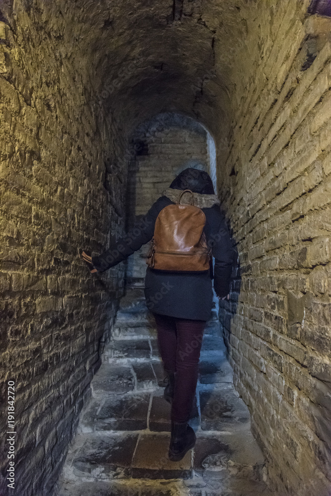 Climber girl climbing stairs of an old medieval crypt, Go up and discovery concept