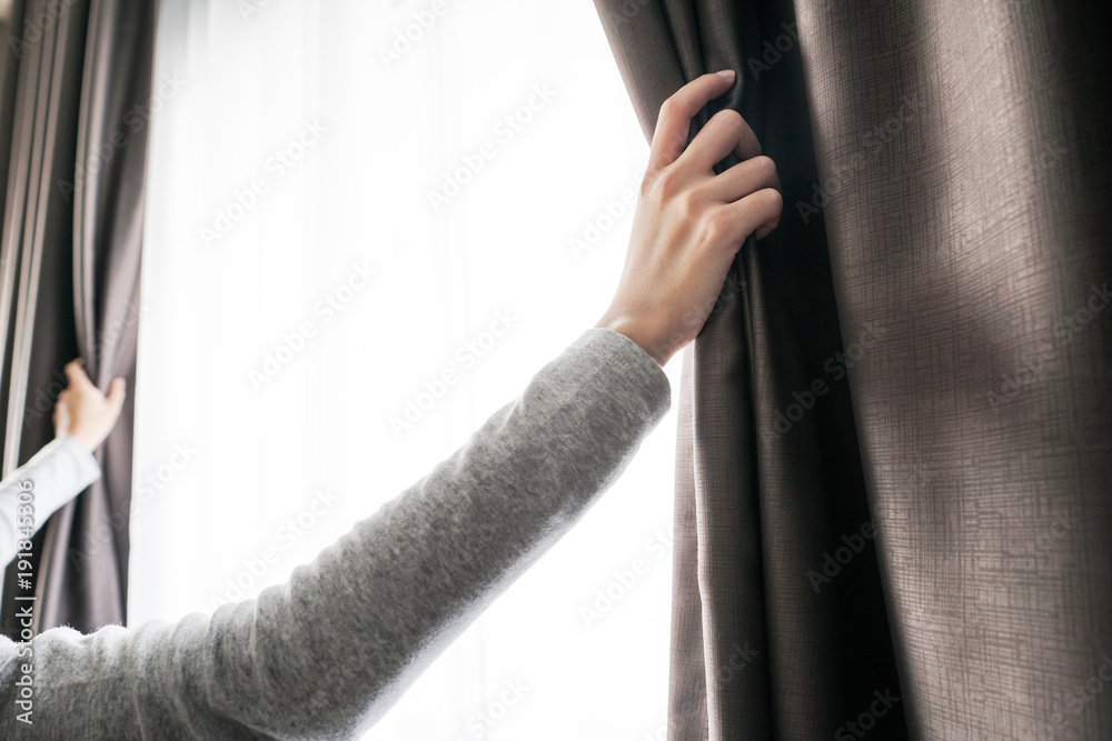 closeup of women hand opening curtain